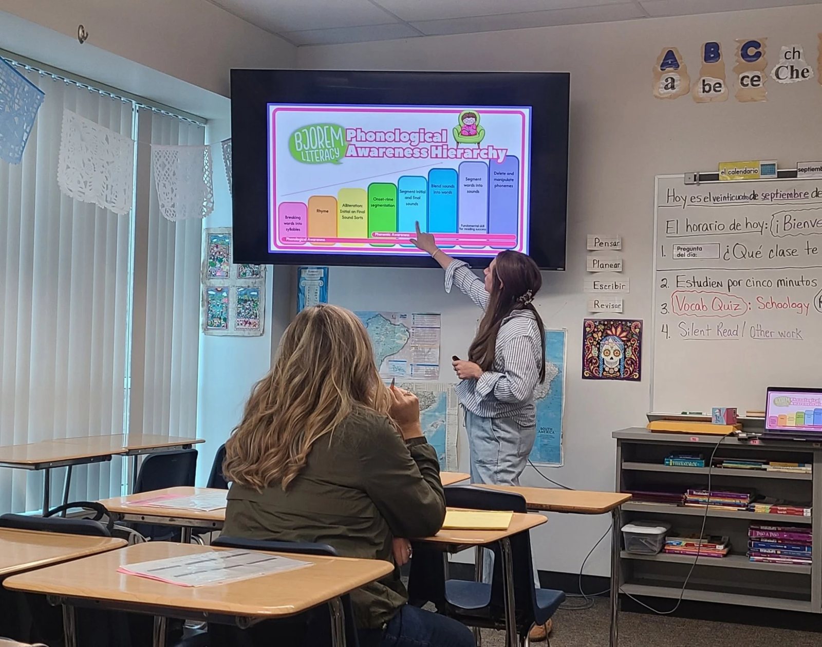 Lauren Kline pointing to a phonological awareness hierarchy on screen while leading a training session